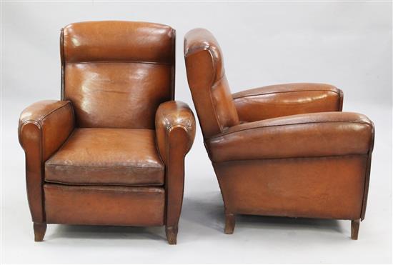 A pair of 1940s French brown leather upholstered club armchairs